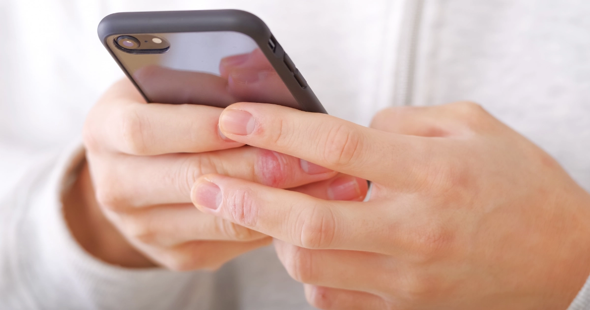 退去費用について両手でスマートフォンを操作して調べている様子