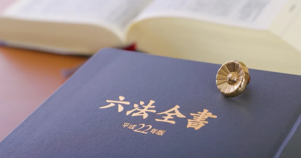 退去費用・原状回復の問題解決に役立つ六法全書と弁護士バッジ