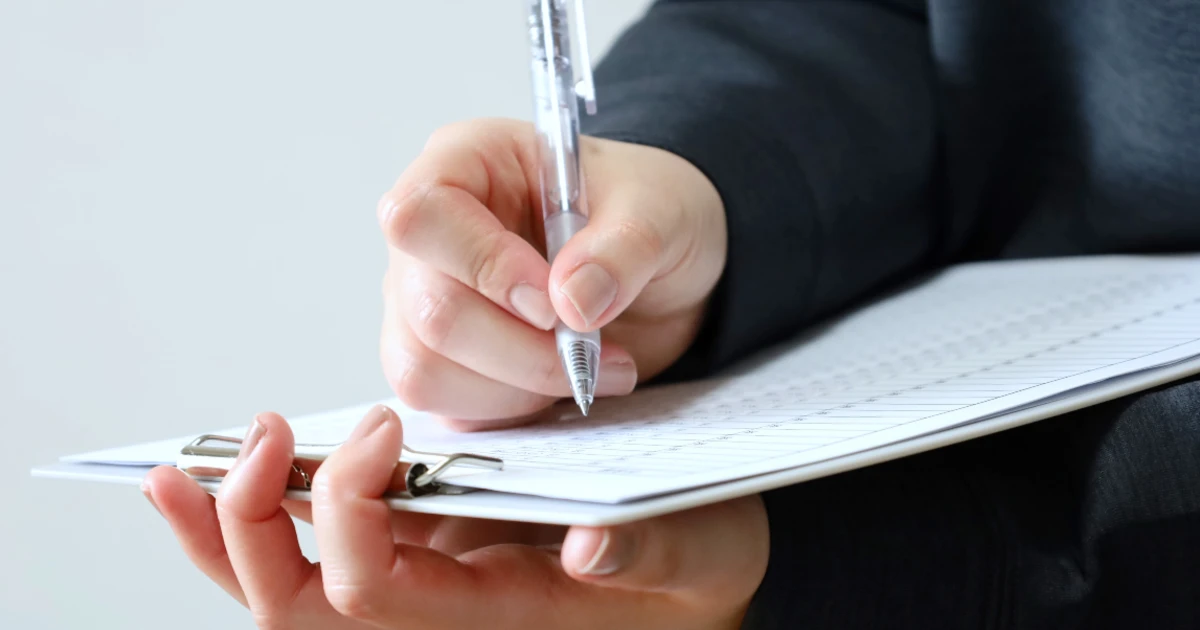 退去時の書類に男性がサインをしている様子