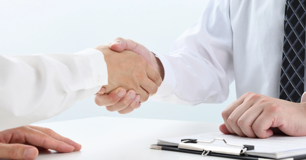 退去費用のトラブルが解決して管理会社と借主が握手をしている様子