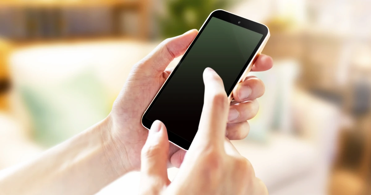 退去費用についてスマートフォンで情報を調べている様子