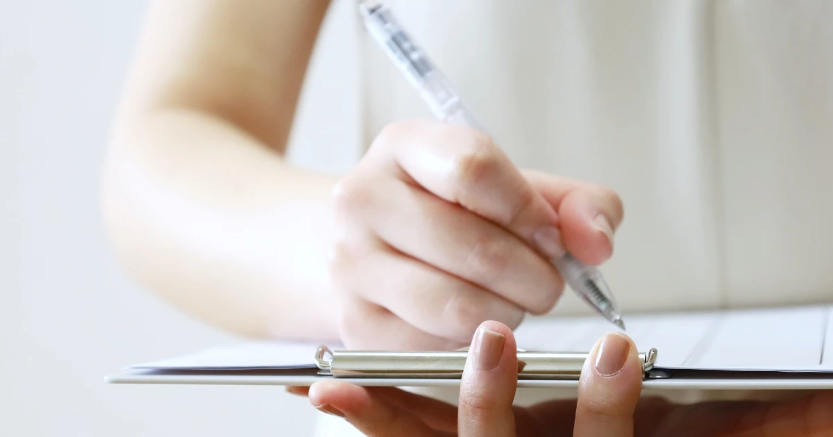 退去時の書類に女性がサインをしている様子